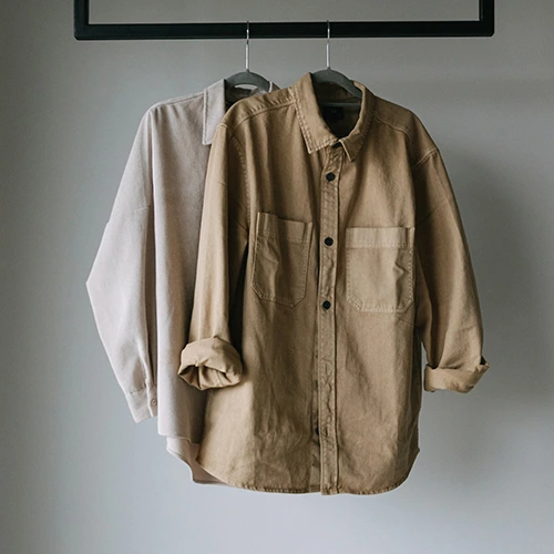 two light colored shirts hanging